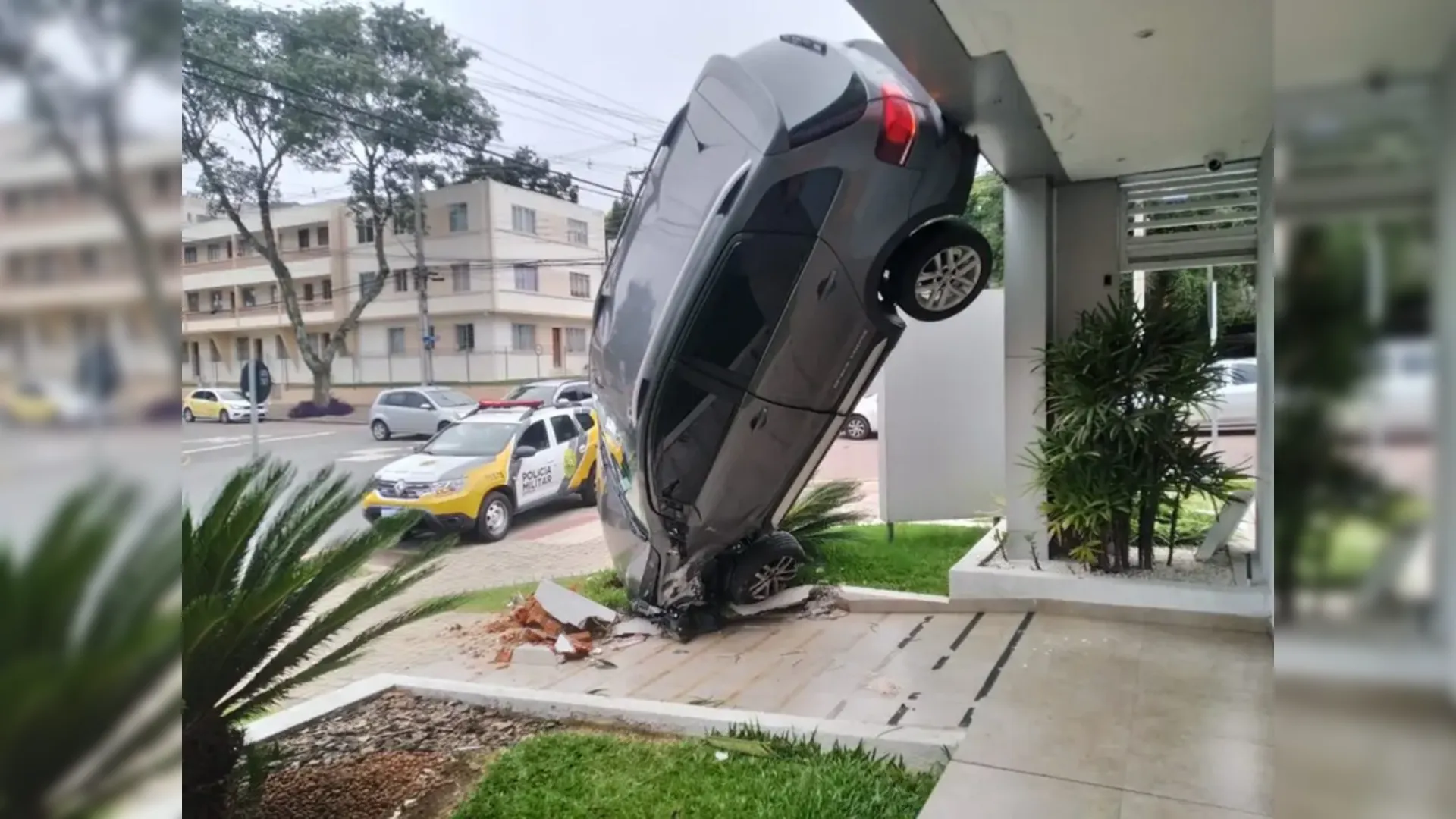 Motorista cochila e carro fica pendurado no estacionamento