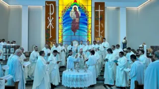 Padres e o bispo rezam juntos na bênção dos santos óleos.