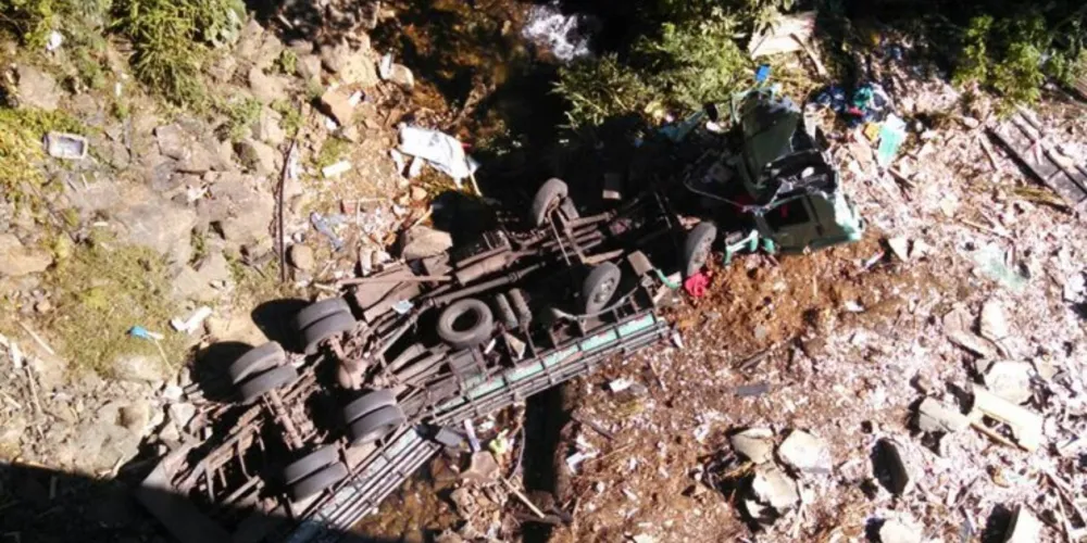 Imagem ilustrativa da imagem Caminhão bate contra carro e despenca em barranco